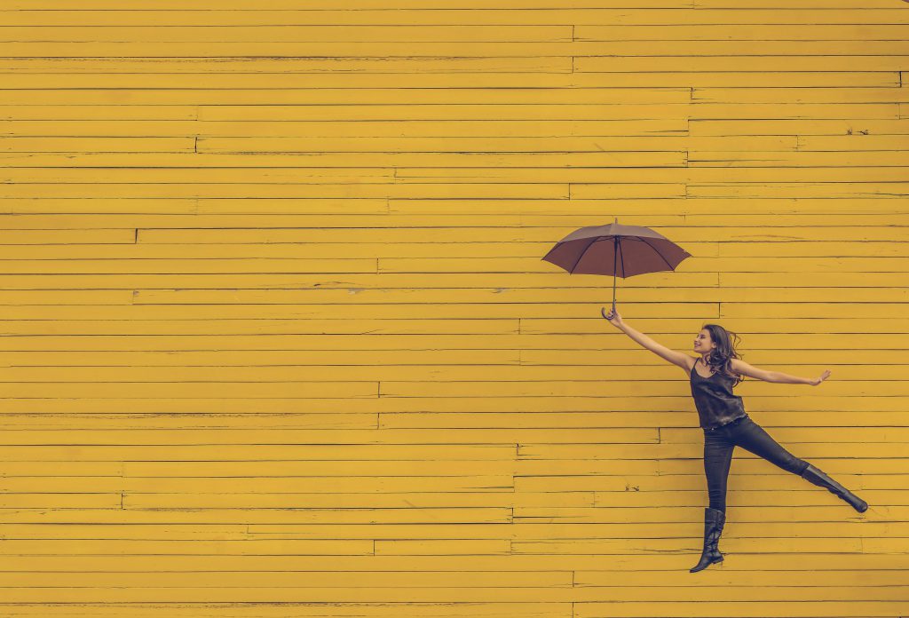 girl jumping, holding umbrella